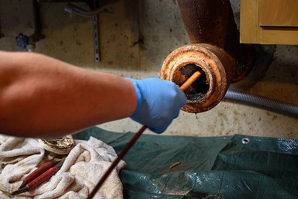 homme débouchant une canalisation